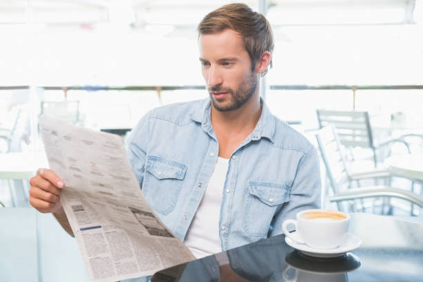 istock Young man reading the newspapers 692357142