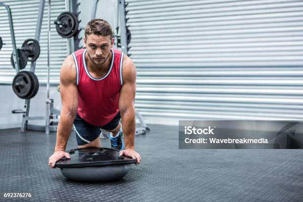 Portrait Of Muscular Man Using Bosu Ball Stock Photo - Download Image Now - 20-29 Years, 25-29 Years, Active Lifestyle