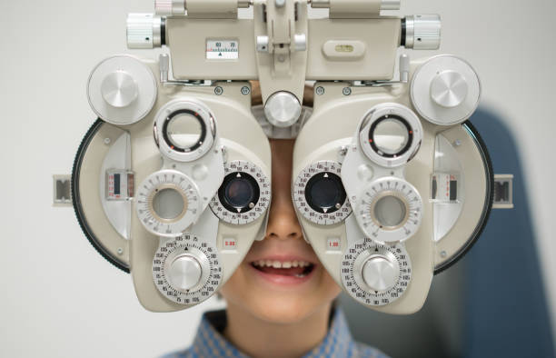 Young patient getting an eye exam at the optician Young patient getting an eye exam at the optician on the phoropter â healthcare and medicine concepts myopia stock pictures, royalty-free photos & images