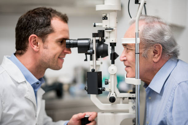 paciente mayor que un examen ocular en el óptico - eye exam eyesight doctor healthcare and medicine fotografías e imágenes de stock