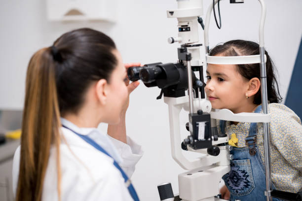istock Girl getting an eye exam at the optician 692381788