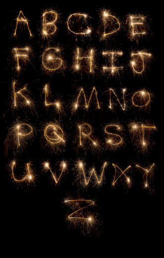 A stock photo of the Letters of the Alphabet made using Sparklers. Isolated on a black background.