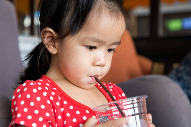 istock girl drink water from the plastic glass 692387492
