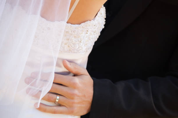 istock Mid section of newlywed couple embracing 692387548