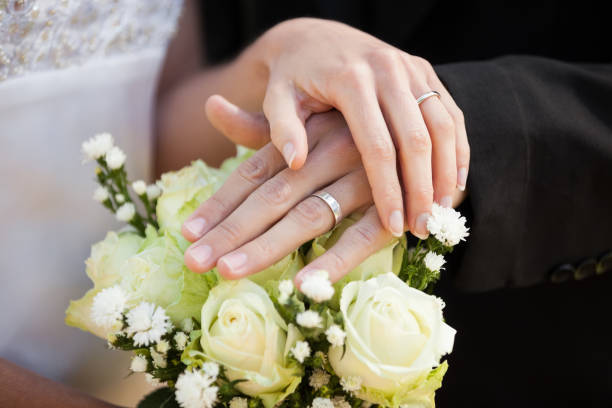 istock Newlywed couple with wedding rings and bouquet 692389744