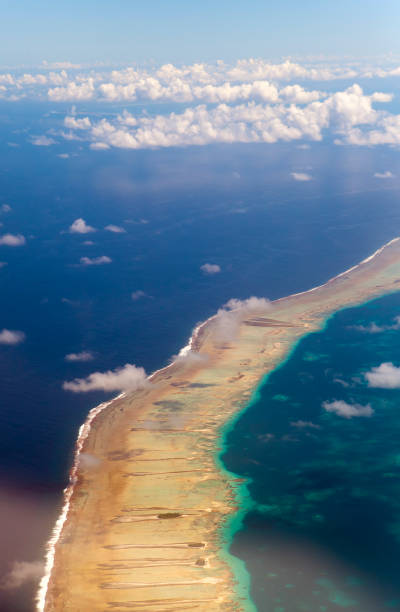 istock Polynesia. The atoll in ocean through clouds. Aerial view. 692397240