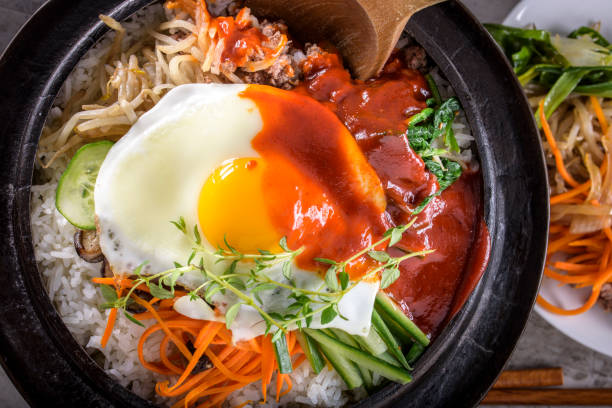 istock BI Bim Bap, Rice with Mixed Vegetables, top view with Hot Sauce in Cast Iron Pot 692403076