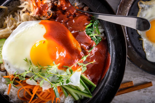 istock BI Bim Bap, Rice with Mixed Vegetables, top view with Hot Sauce in Cast Iron Pot 692403122