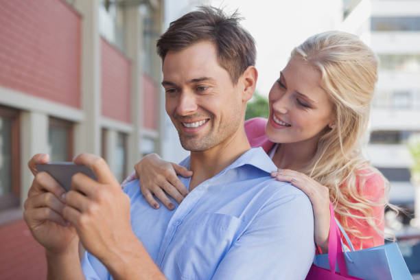 istock Stylish young couple looking at smartphone 692406530