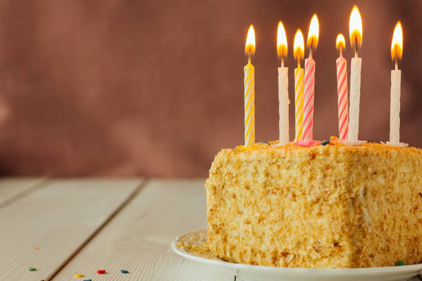 istock Birthday cake with candles on wooden table 692416372