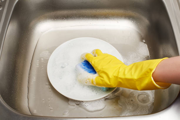 istock Hand in glove washing plate with blue cleaning sponge 692419440