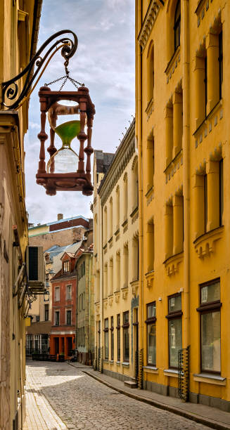 istock Decorative sand-clock in narrow medieval street, Riga, Latvia. 692422300