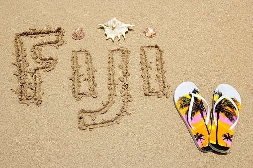 Word Fiji written on a beach - travel concept