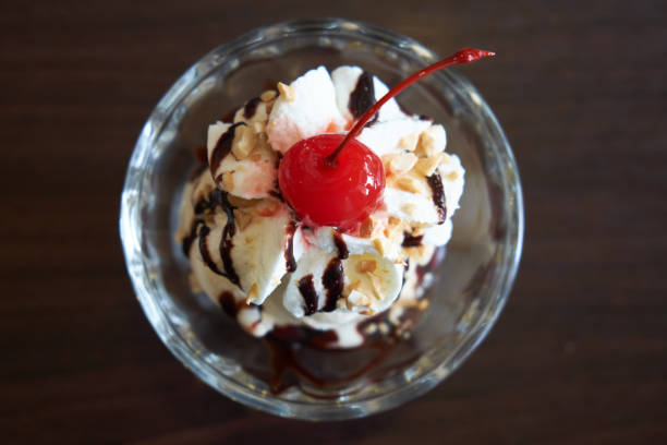 istock Ice cream chocolate and vanilla sundae topping with red cherry. 692423666