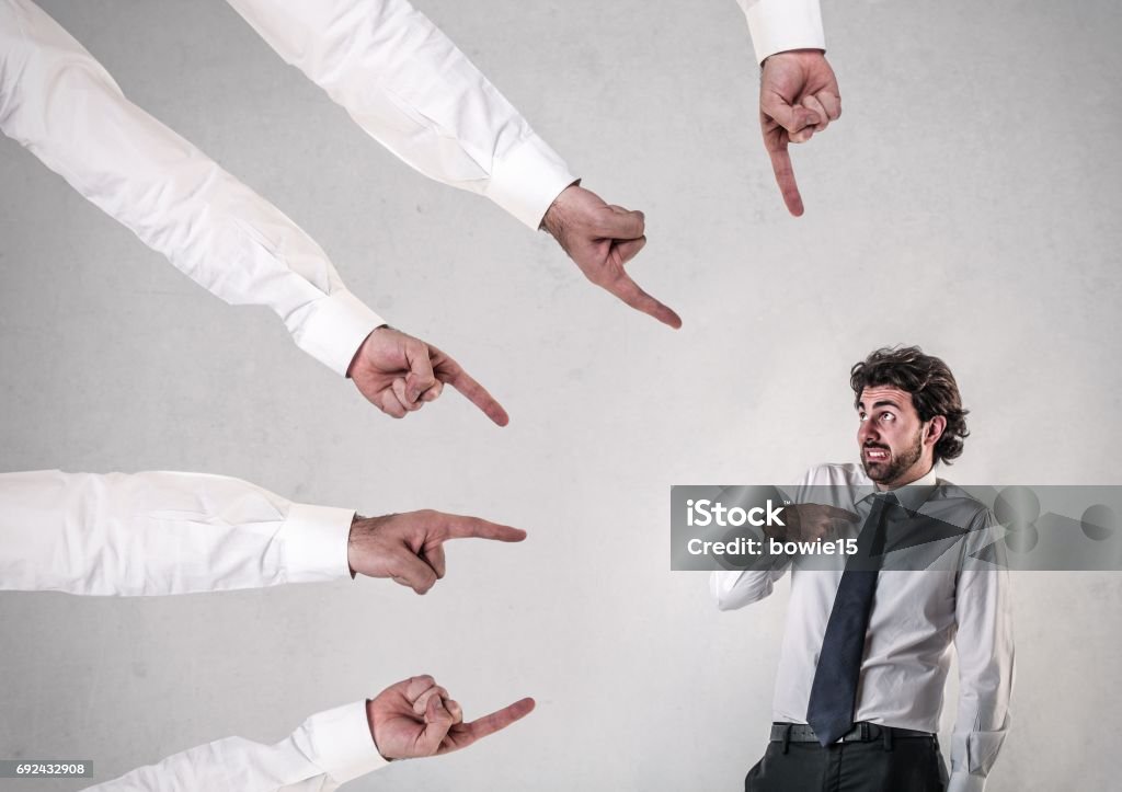 Your fault Five hands are pointing at a worker, that it is his fault Adult Stock Photo