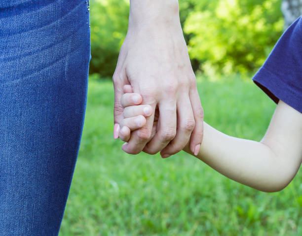 istock Mom holds the child's hands. 692438290