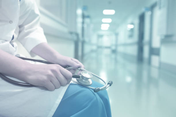 Shot of an exhausted doctor sitting in a hospital corridor