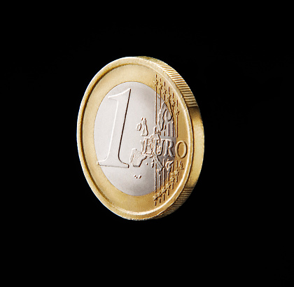 One euro coin isolated on black background.