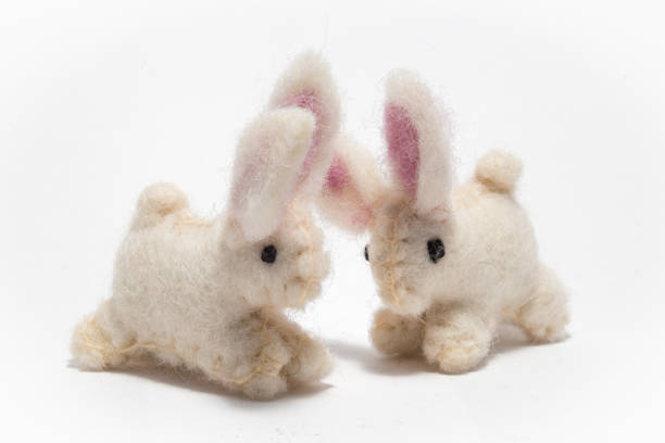 istock Hand made miniature craft Easter rabbits on a white background 692444900