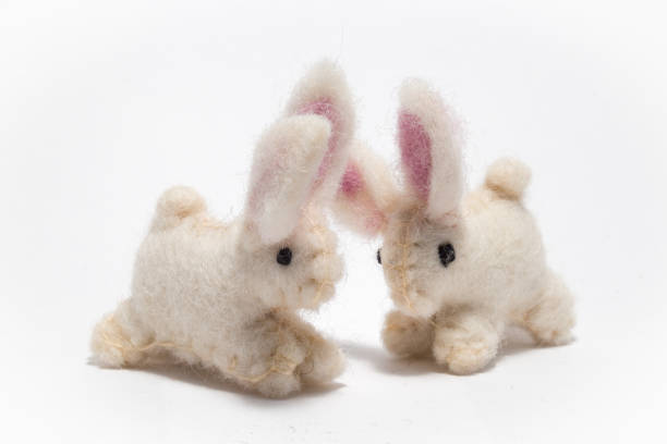 istock Hand made miniature craft Easter rabbits on a white background 692444938