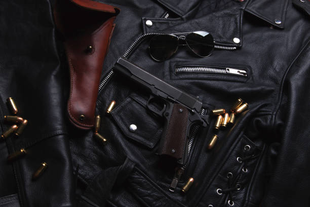istock Gun Colt with bullets and holster rests on a leather jacket 692449626