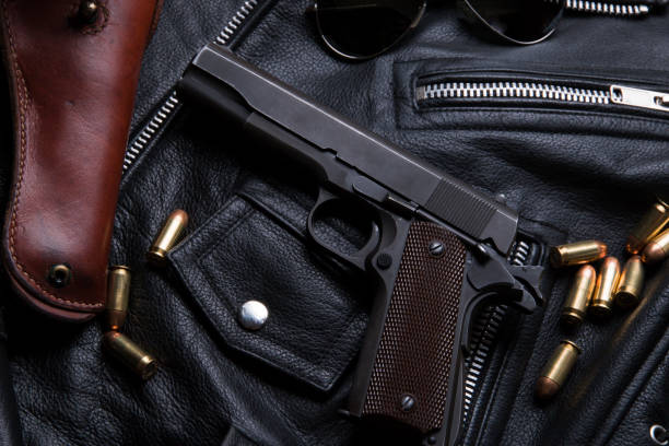 istock Gun Colt with bullets and holster rests on a leather jacket 692449632