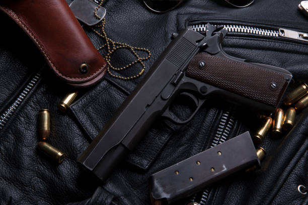 istock Gun Colt with bullets and holster rests on a leather jacket 692449648