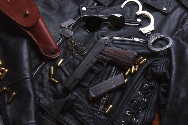 istock Gun Colt with bullets and holster rests on a leather jacket 692449690