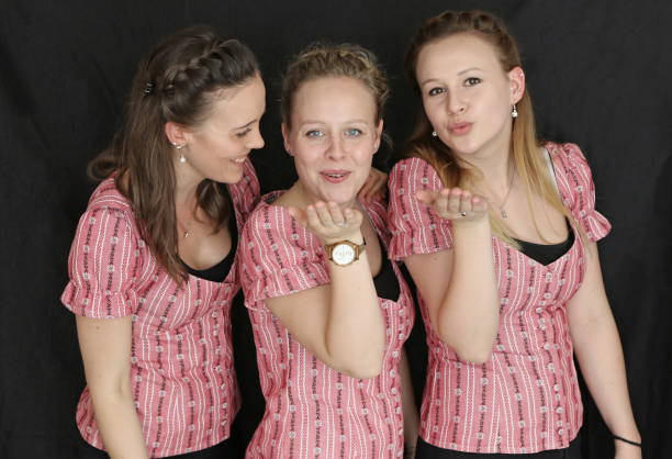 Three Swiss Sisters Sisters posing, showing happiness. kiss entertainment group stock pictures, royalty-free photos & images