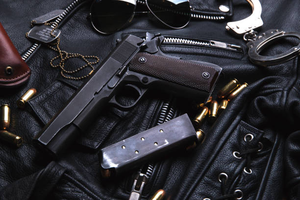 istock Gun Colt with bullets and holster rests on a leather jacket 692449730