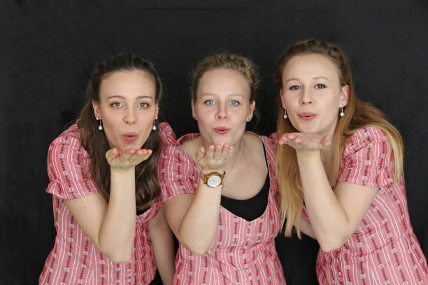 Three Swiss Sisters Sisters posing, showing happiness. kiss entertainment group stock pictures, royalty-free photos & images