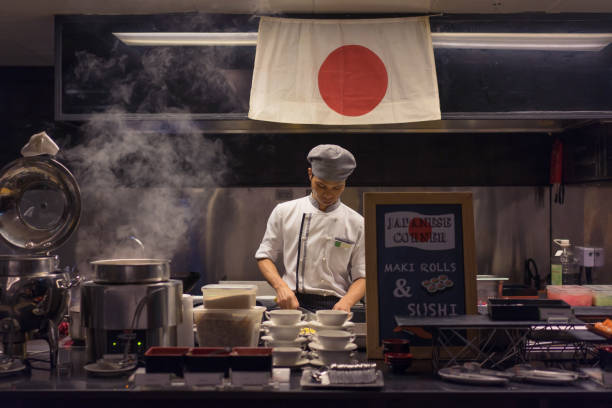 tailândia, bangkok – 7 de fevereiro de 2017: chef asiático é cozinhar e cortar comida japonesa em uma cozinha de restaurante japonês autêntico. - sushi japan restaurant food - fotografias e filmes do acervo