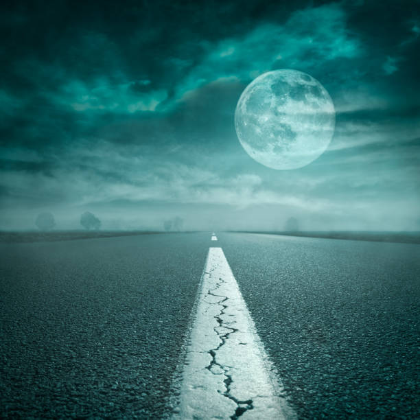 istock Driving on open road towards the super moon at night 692462502