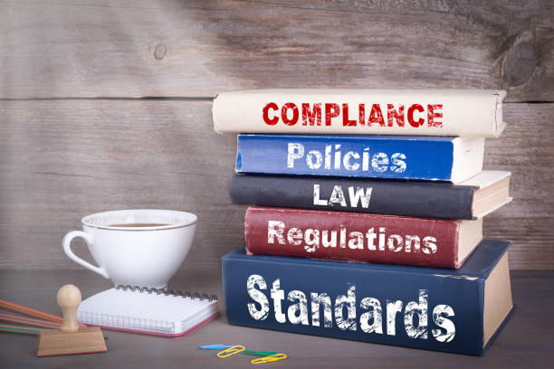 Compliance concept. Stack of books on wooden desk