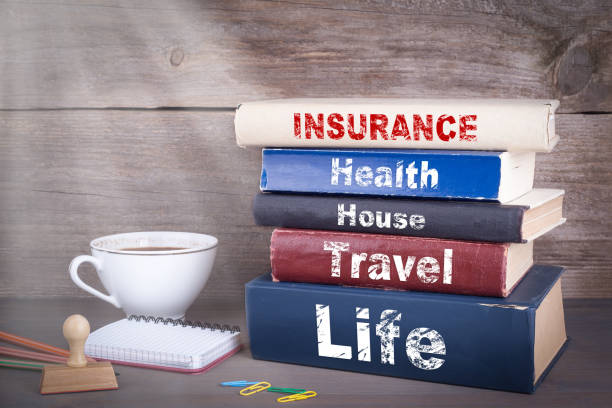 istock insurance concept. Stack of books on wooden desk 692472826