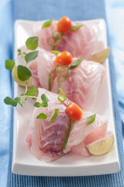 istock raw white fish fillets with tomatoes and fresh oregano & Lemon slice 692475882