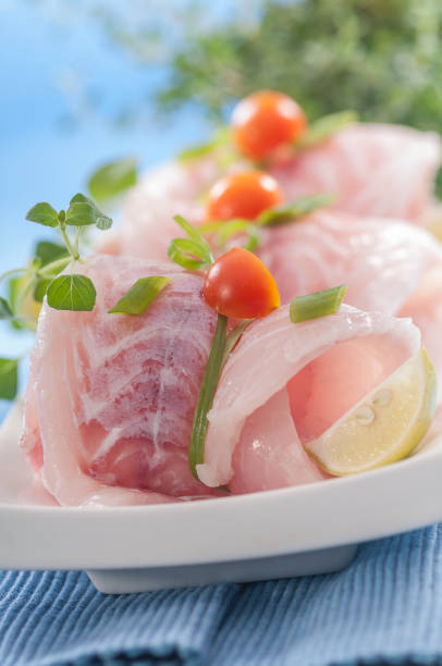 istock raw white fish fillets with tomatoes and fresh oregano & Lemon slice 692475886