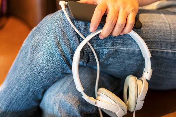 istock hand holding headset and smart phone on leg 692476884
