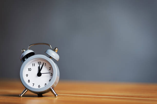 istock metal old alarm clock on wood table 692477080