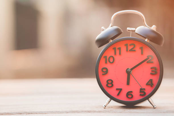 istock Retro alarm clock on wooden table, vintage style 692495770