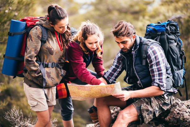 istock Young hiker friends reading a map for directions 692495790
