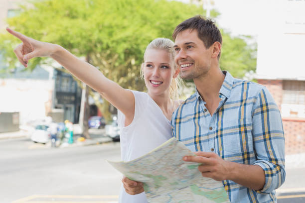 istock Young tourist couple consulting the map and pointing 692519328