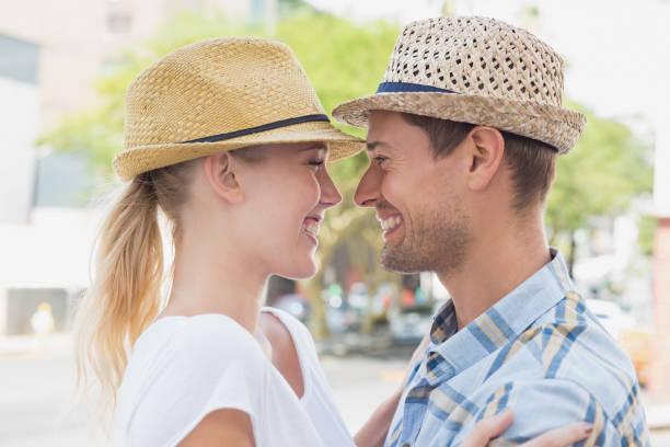Young hip couple hugging and smiling at each other on a sunny day in the city