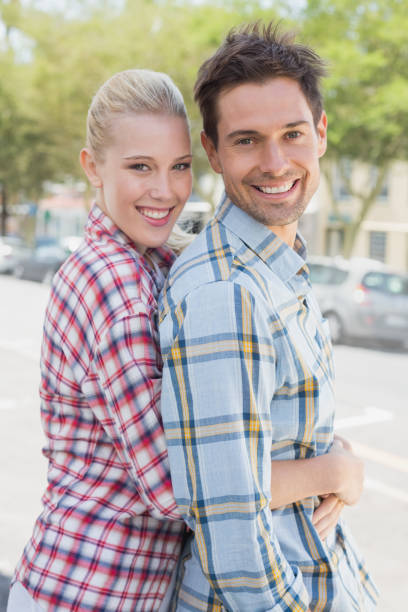 istock Young hip couple standing and hugging smiling at camera 692523436
