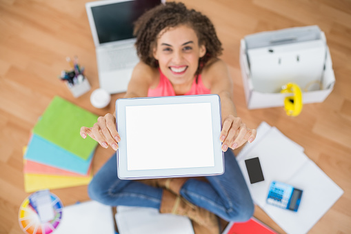 Portrait of a young creative businesswoman showing her tablet