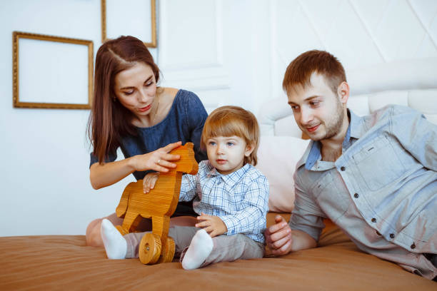 istock parents with a child playing on bed with toys 692529822