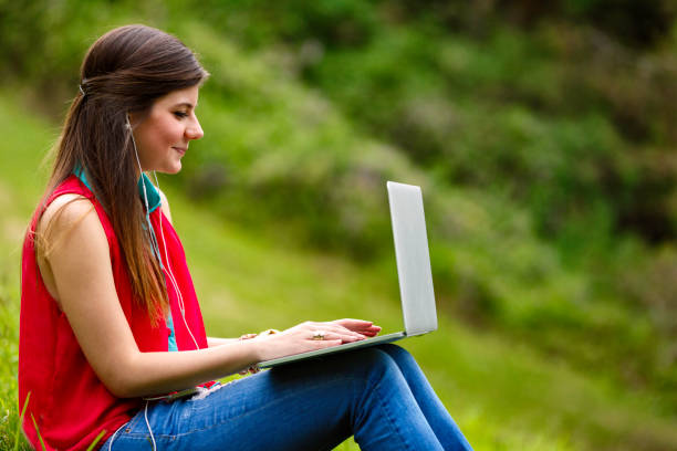 istock Happy young student listening to music and using wireless laptop at university campus 692534010