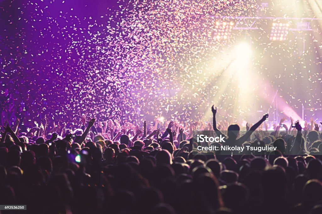 View of rock concert show in big concert hall, with crowd and stage lights, a crowded concert hall with scene lights, rock show performance, with people silhouette Celebration Stock Photo