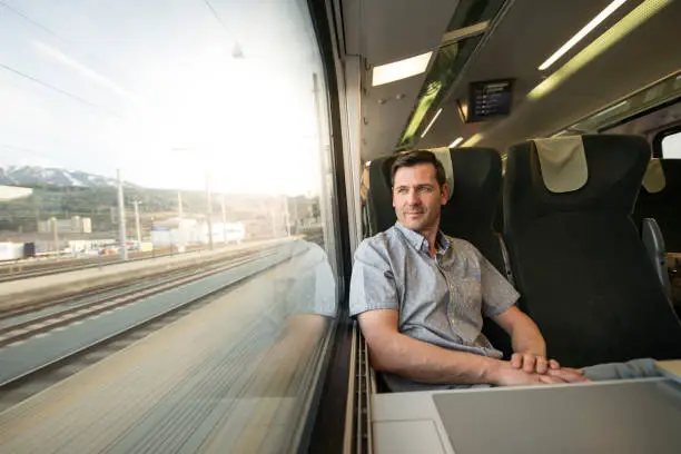 Photo of Businessman looking out of window during traveling by train