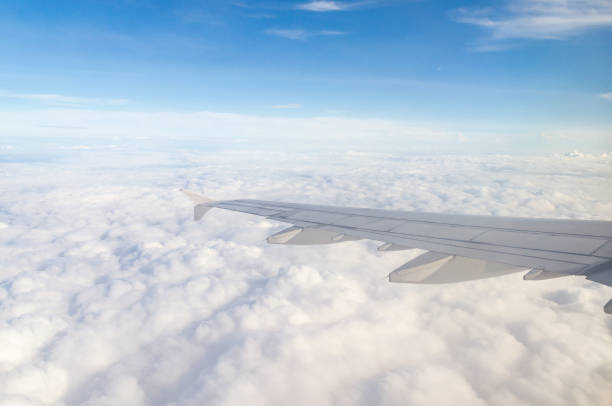istock Wing of airplane flying above the cloud 692542280